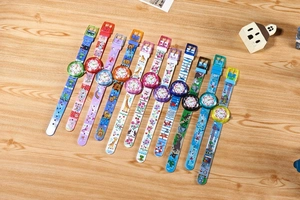 Flat lay of colorful kids analog watches with cartoon patterns on wooden background