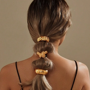 Irregular textured gold metal hair ties shown on a bubble ponytail in a professional display
