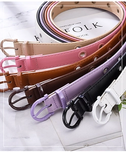 Close-up of assorted faux leather belts with colorful eyelets and D-shape buckles
