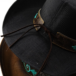 Close-up of woven cowboy hats with embroidered floral bands and leather ties