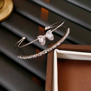 Detail of silver double-layer bracelet featuring zircon butterfly and heart-shaped stones