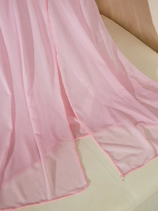 Détail du tissu en maille rose transparent avec ourlet délicat et texture légère