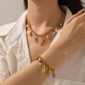 Détail de pendentifs anges et étoiles dorés avec perles colorées sur des chaînes épaisses