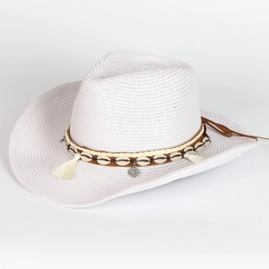 Detail of white straw cowboy hat with shell decorations, fringe, and vintage coin charm