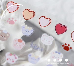 Detailed close-up of cute cartoon bear and heart nail stickers on PET transparent film