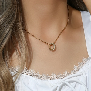 Golden rope chain necklace with a sparkling round zircon pendant on a model