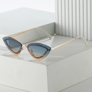 Detailed view of cat eye sunglasses with gold metal frame and gradient blue-brown lenses