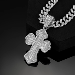 Detailed macro view of an iced-out silver Cuban chain with a diamond-encrusted cross pendant