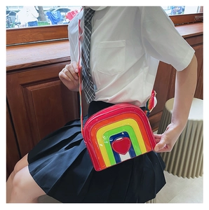 Detail of a rainbow heart crossbody bag with adjustable strap on a female model