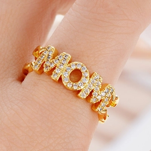 Macro detail of gold-plated MOM ring with micro-paved white zircons on double band