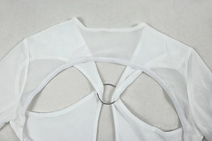 Detail of white mesh dress featuring metal ring cutout and sheer fabric texture