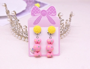 Detail of cute yellow and pink candy-shaped clip-on earrings for kids on bow card