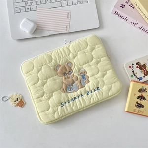 Vista detallada de la funda acolchada para portátil con bordado de oso y perro
