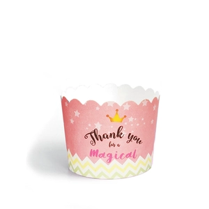 Detail of pink paper muffin cup featuring crown patterns and magical script typography