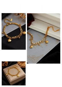 Detailed macro view of a gold-plated stainless steel double-layer heart charm bracelet