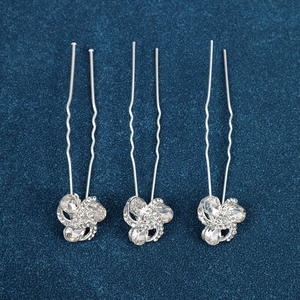 Detail of silver U-shaped hair pins with sparkling rhinestone flower knot designs