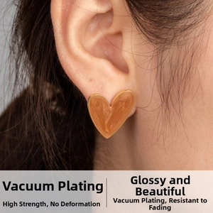 Close-up of minimalist heart stud earring with marble pattern worn by a model