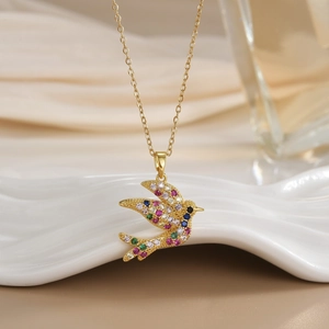 Close-up of golden bird pendant necklace with colorful micro-inlaid zircon crystals