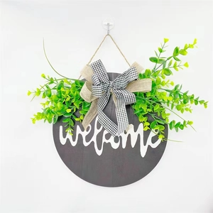 Round wooden welcome sign with eucalyptus leaves and buffalo plaid bow for front door