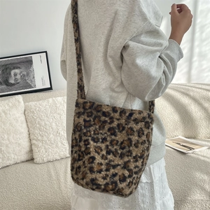 Leopard print plush shoulder bag on female model in a cozy interior setting