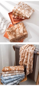 Detail of folded cashmere-style scarves with floral prints and tassel fringe edges