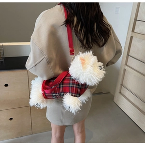 Detail of cartoon dog plush bag featuring red plaid fabric and adjustable strap