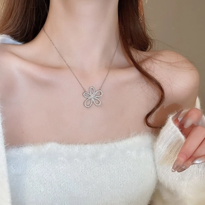 Close-up of a silver flower pendant necklace with sparkling diamonds on a model neck