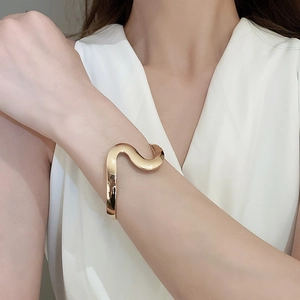 Close-up of minimalist gold wave bangle on wrist with a modern minimalist design