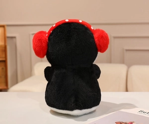 Back view of plush penguin doll with black fur and red polka dot earmuffs detail