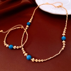 Vue détaillée du parure collier et bracelet plaqué or 18K sur un tissu en soie sombre
