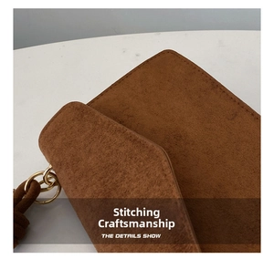 Detail of brown matte suede bag showing precise stitching and gold metal hardware