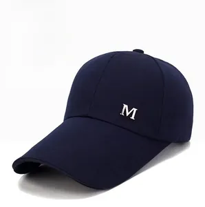 Gros plan d'une casquette de baseball en toile bleu marine avec logo M en métal argenté
