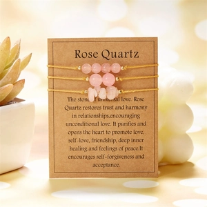 Detailed view of three rose quartz stone bracelets on a kraft card with yellow braided cords