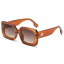 Detail view of retro oversized square amber frames with gradient brown lenses