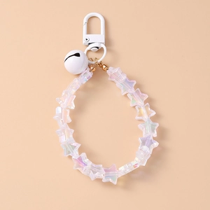 Close-up of star-shaped beads and white bell keychain with iridescent finish