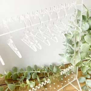 Close-up of a clear acrylic mini clothes hanger rack for creative earring jewelry display