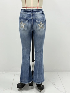 Detail showing back pocket with sequin star embroidery and flared leg denim finish
