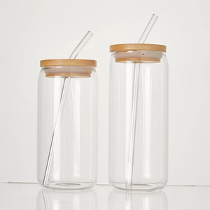 Detail of two clear 16oz glass cups with eco-friendly bamboo lids and reusable straws