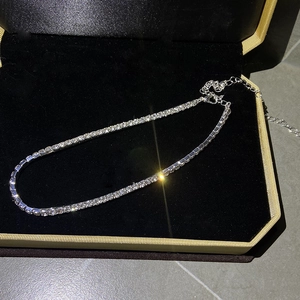 Gros plan d'un collier tennis étincelant en diamant dans son coffret cadeau beige