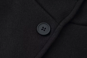 Macro shot of black woolen coat fabric and high-quality round four-hole buttons