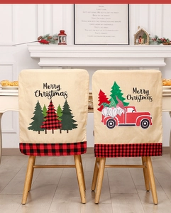 Linen Christmas chair covers with festive red truck and tree motifs in a cozy home setting