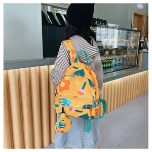 Detail of yellow floral kids backpack with green straps and small matching coin purse