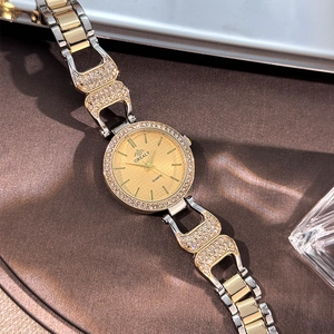 Détail montre GREALY luxe quartz avec lunette diamantée et cadran doré à motif grillagé