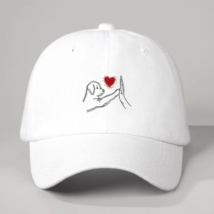Detail of white baseball cap featuring minimalist high-five puppy heart illustration