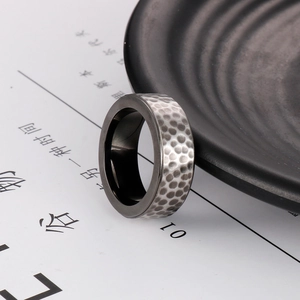 Close-up of dual-tone titanium ring with silver hammered surface and black inner band