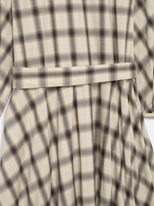 Détail de la taille d'une robe chemise à carreaux beige avec ceinture assortie en tissu tissé