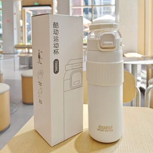 Detailed view of white 700ml insulated sports bottle and packaging on wood table