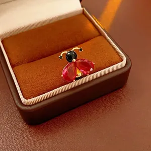 Vintage ladybug brooch with red pear-cut gems and black stones in a gold metal base