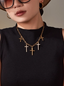 Détail macro du collier croix plaqué or 18k avec zircons 5A porté par un mannequin