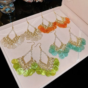 Detail of bohemian shell tassel earrings with pearls in multiple colors in a velvet box